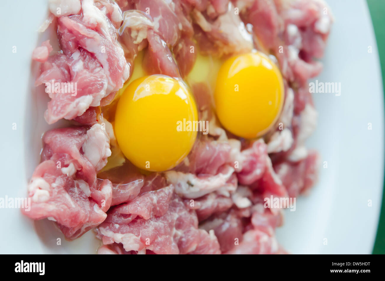 La carne cruda e fresca di maiale affettato , Tuorlo d'uovo preparare per la cottura. Foto Stock
