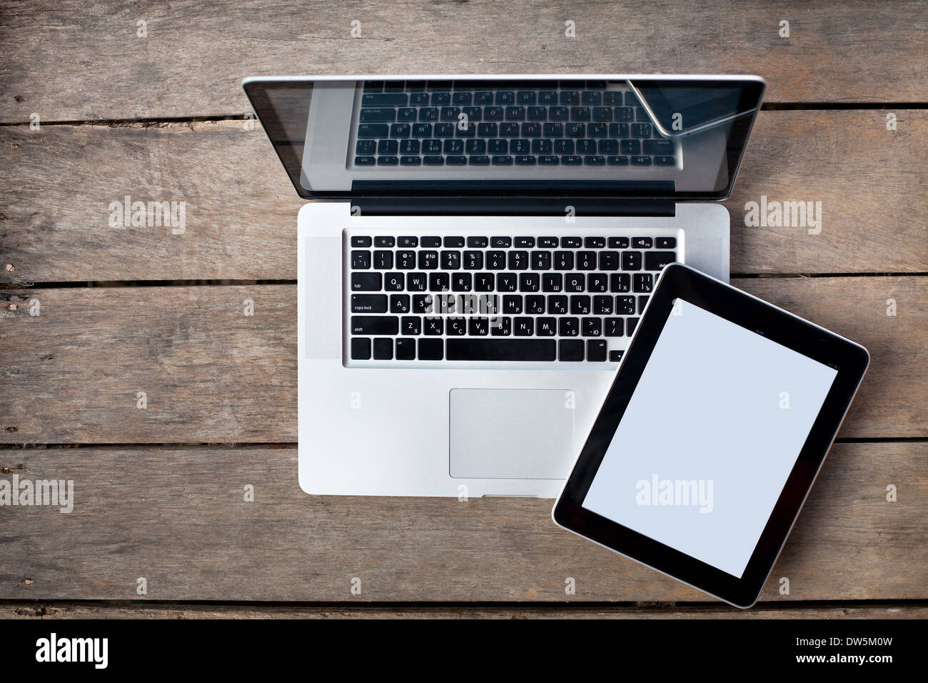 Laptop e tablet su una vecchia scrivania in legno Foto Stock