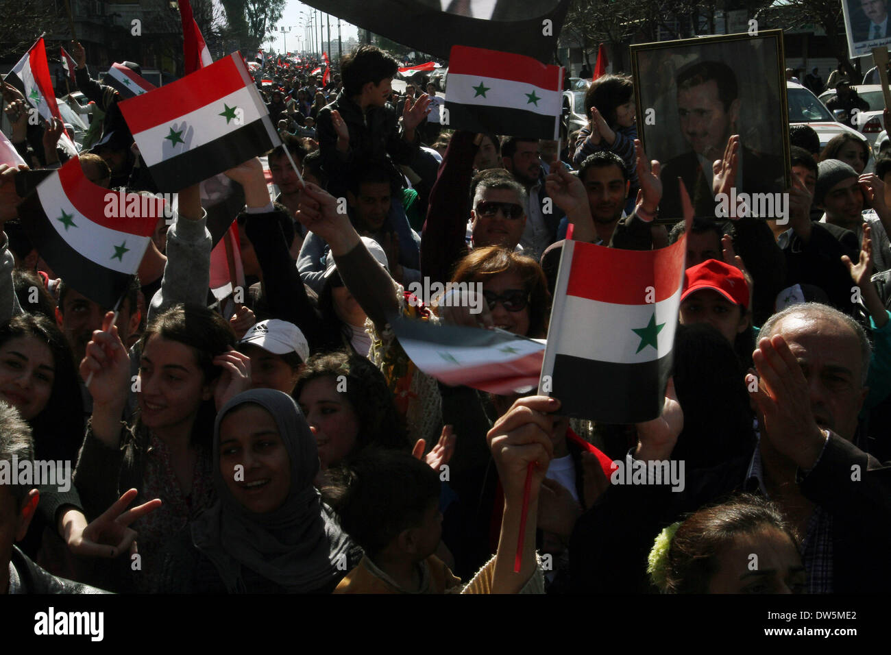 Damasco, Siria. 28 feb 2014. I sostenitori del Presidente siriano Bashar al-Assad siriano onda bandiere nazionali durante un rally in Damasco, Siria, il 28 febbraio, 2014. Credito: Bassem Tellawi/Xinhua/Alamy Live News Foto Stock