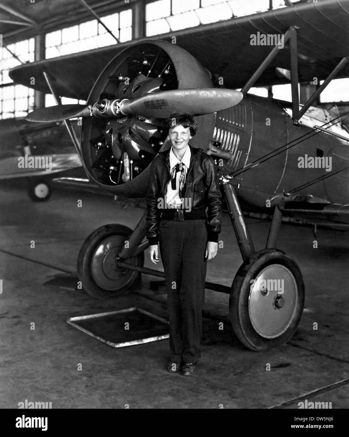 Pioniere dell'aviazione Amelia Earhart pone con il suo aereo in un hangar Luglio 30, 1936. Earhart fu il primo aviatore femmina a volare in solitaria attraverso l'Oceano Atlantico Foto Stock