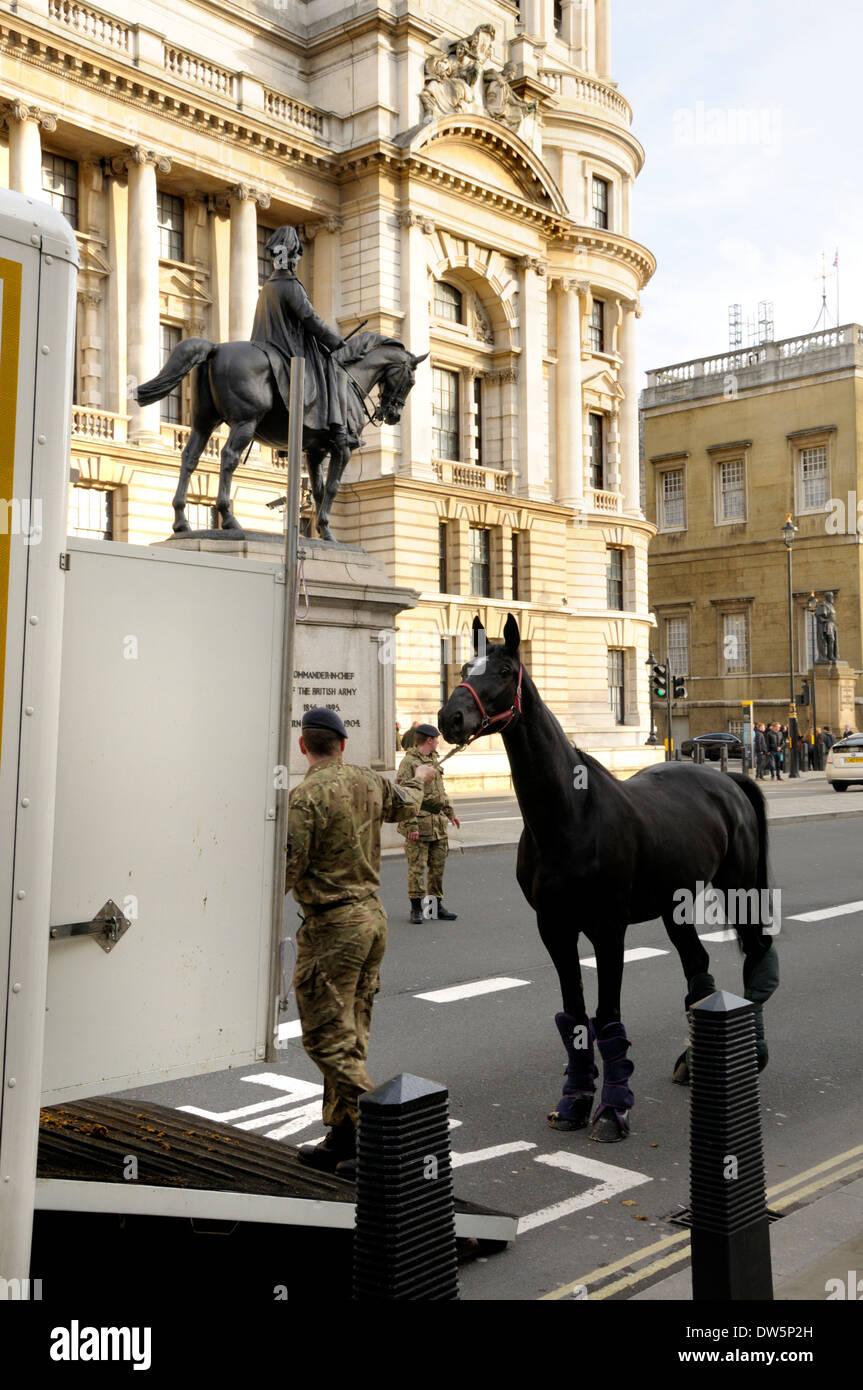 Londra, Inghilterra, Regno Unito. Soldato in Whitehall portando un cavallo in un van per cavalli dalla statua equestre del Duca di Cambridge Foto Stock