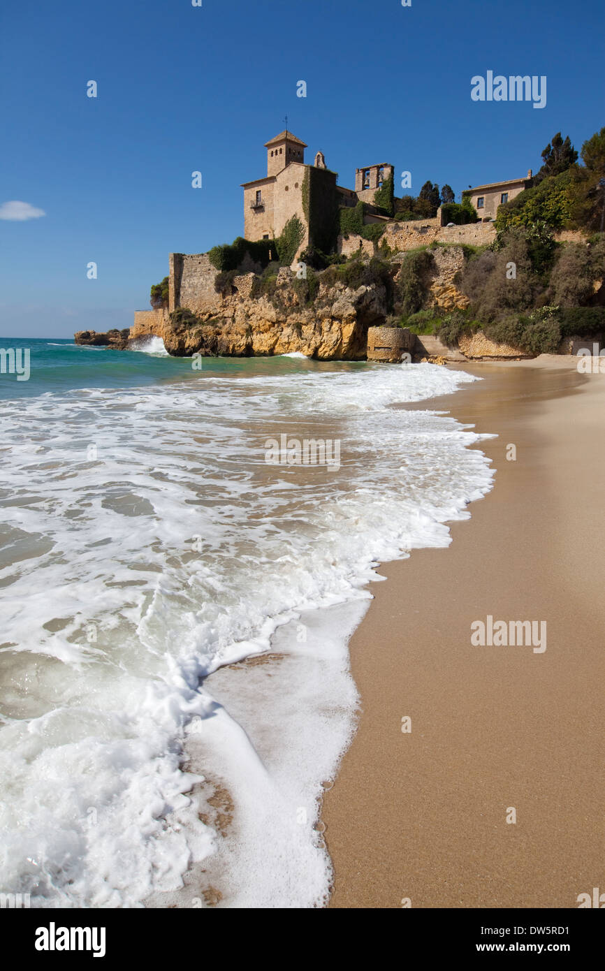 Schiuma di mare sulla spiaggia di Tamarit con il castello in background, provincia di Tarragona, la Catalogna. Foto Stock