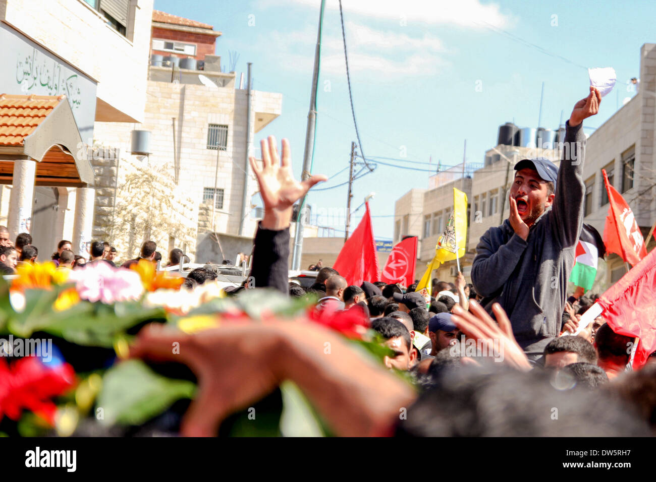 Birzeit, West Bank, Palestina - 28 Febbraio 2014: i palestinesi portano il corpo di Muataz Washaha durante il suo funerale nella West Bank village di Birzeit, vicino a Ramallah . Le forze israeliane hanno aperto il fuoco e ucciso Washaha, che cercavano di cattura in Cisgiordania occupata giovedì dopo l' uomo era asserragliato dentro la sua casa. (Foto di Abdalkarim Museitef/Pacific Press/Alamy Live News) Foto Stock