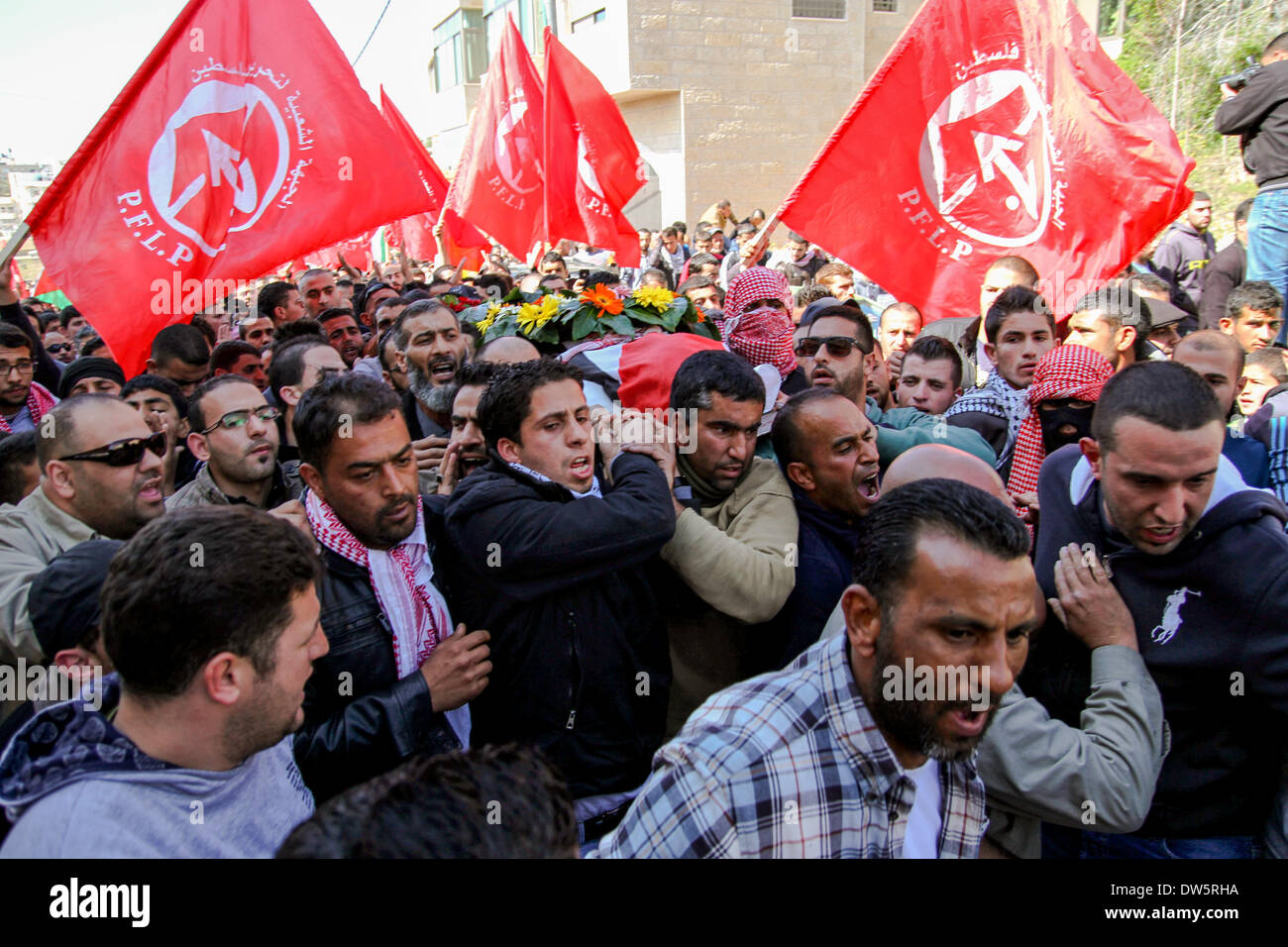 Birzeit, West Bank, Palestina - 28 Febbraio 2014: i palestinesi portano il corpo di Muataz Washaha durante il suo funerale nella West Bank village di Birzeit, vicino a Ramallah . Le forze israeliane hanno aperto il fuoco e ucciso Washaha, che cercavano di cattura in Cisgiordania occupata giovedì dopo l' uomo era asserragliato dentro la sua casa. (Foto di Abdalkarim Museitef/Pacific Press/Alamy Live News) Foto Stock