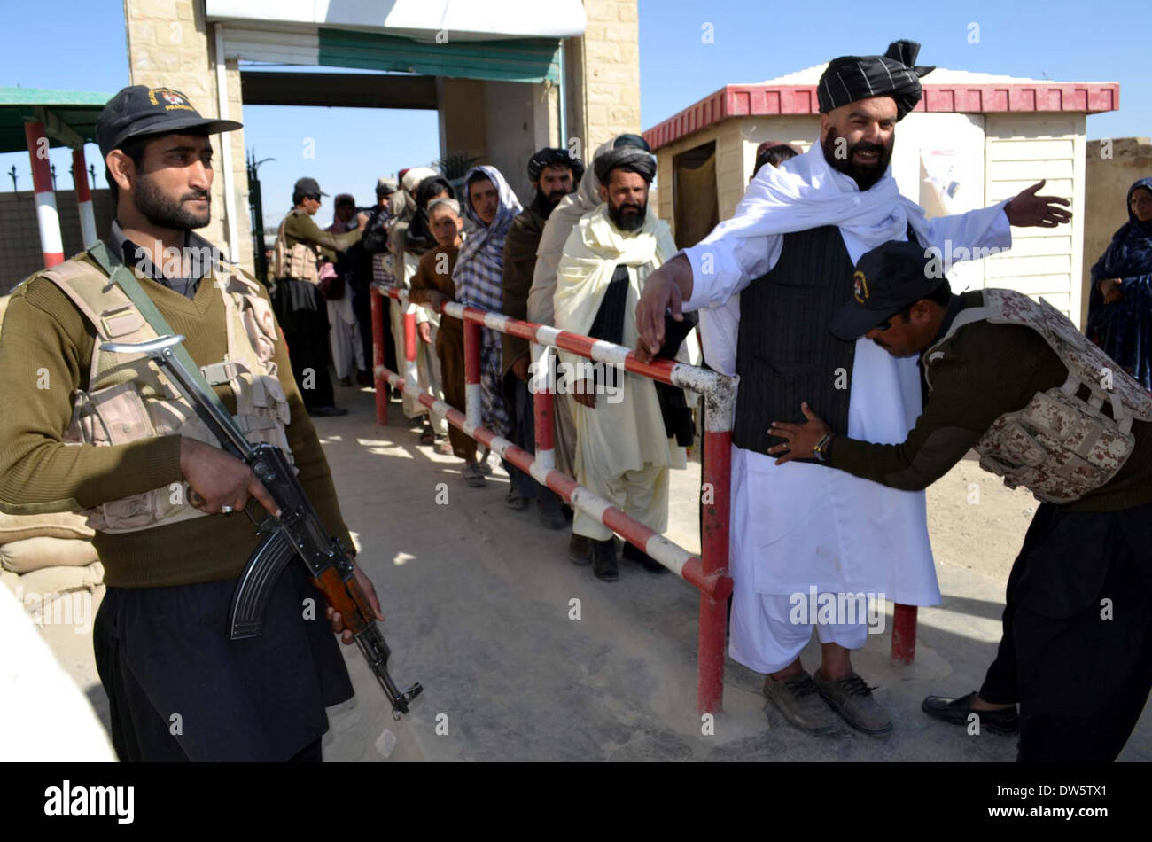 Chaman, Pakistan. 28 feb 2014. Pakistani soldati paramilitari ricerca gli uomini prima di attraversare il cancello di amicizia sul confine Pak-Afghan proveniente in Pakistan da Afghanistan, a Chaman Venerdì 28 Febbraio, 2014. Sicurezza a bordo Pak-Afghan è avviso di alta. Credito: Asianet-Pakistan/Alamy Live News Foto Stock