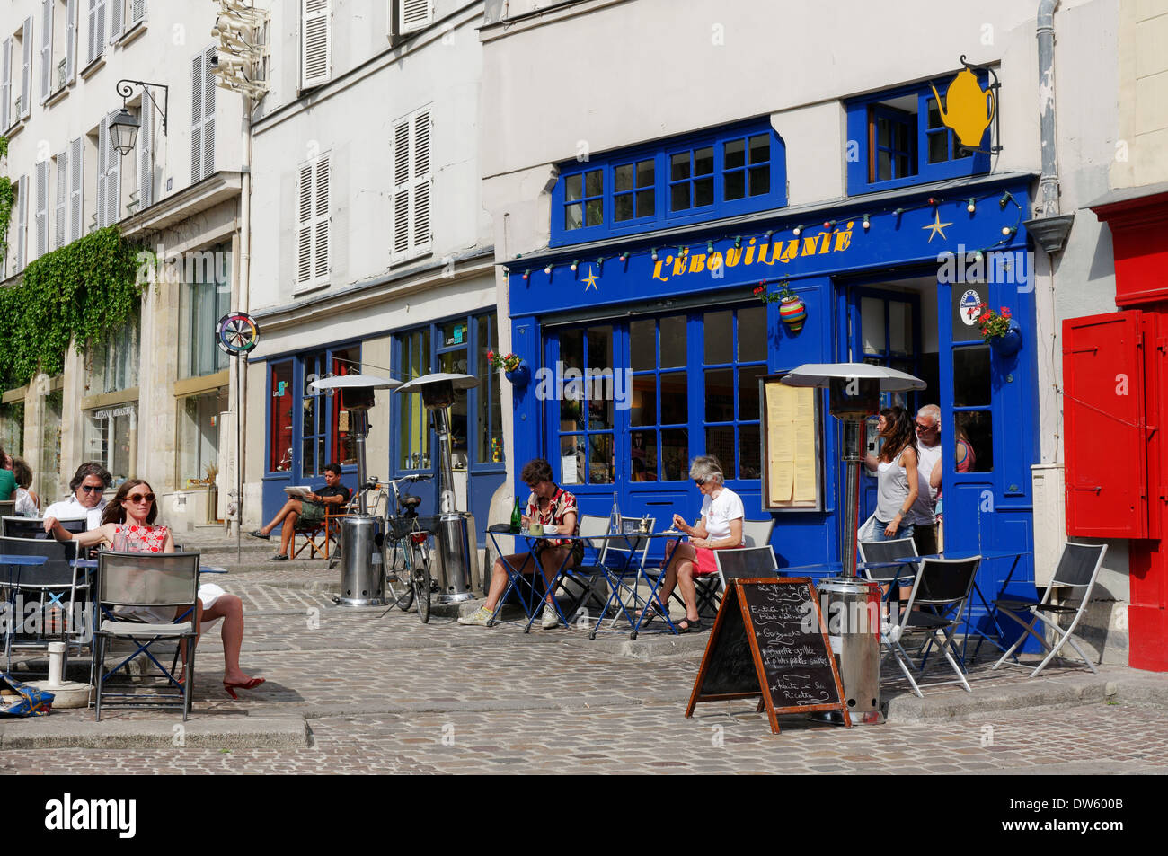 La gente seduta al di fuori di un negozio di tè, nel quartiere Marais di Parigi Foto Stock