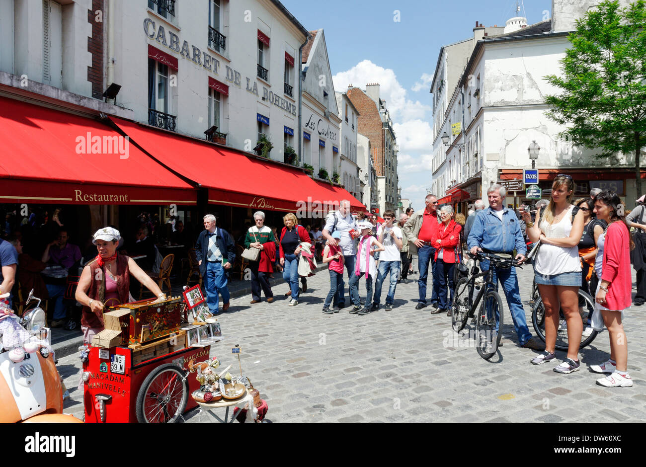 La gente ascolta un organetto player in Place du Tertre, Montmartre, Parigi, Francia Foto Stock