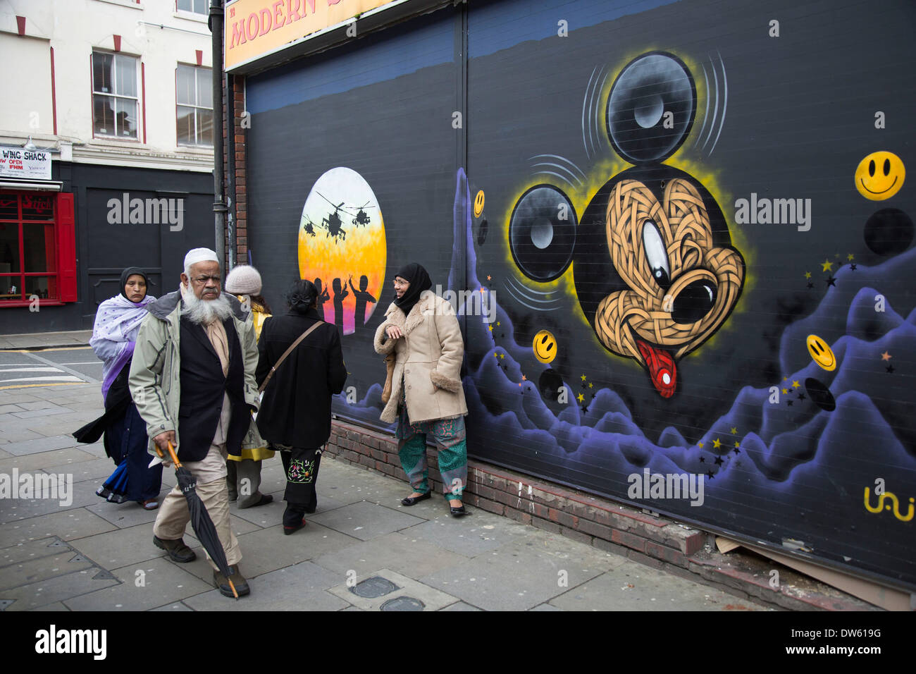 Arte di strada vicino a Brick Lane nell'East End di Londra, Regno Unito. I musulmani a piedi passato un topolino di lavoro. Foto Stock