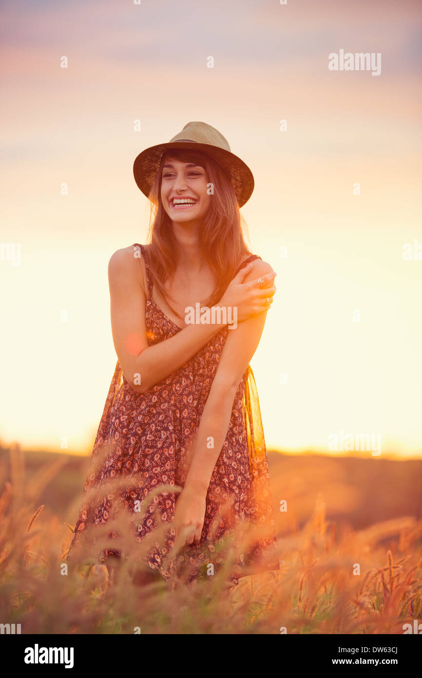 Bella donna felice in campo oro al tramonto e spensierato stile di vita sano, colori vivaci, Retroilluminato toni caldi Foto Stock