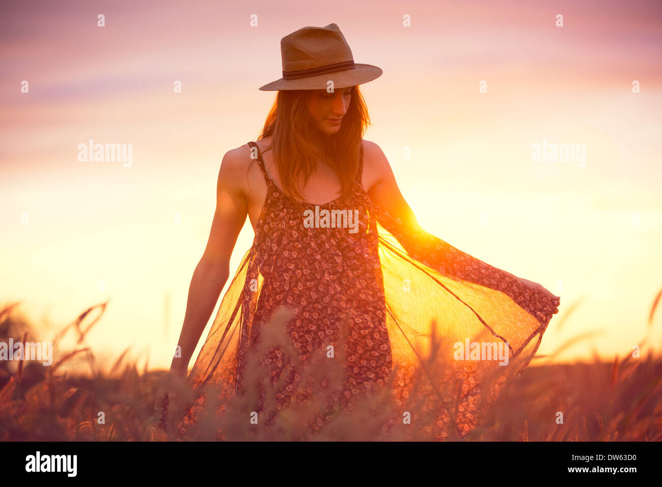 Bella donna nel campo oro al tramonto, fashion lifestyle, colori brillanti, Retroilluminato toni caldi Foto Stock