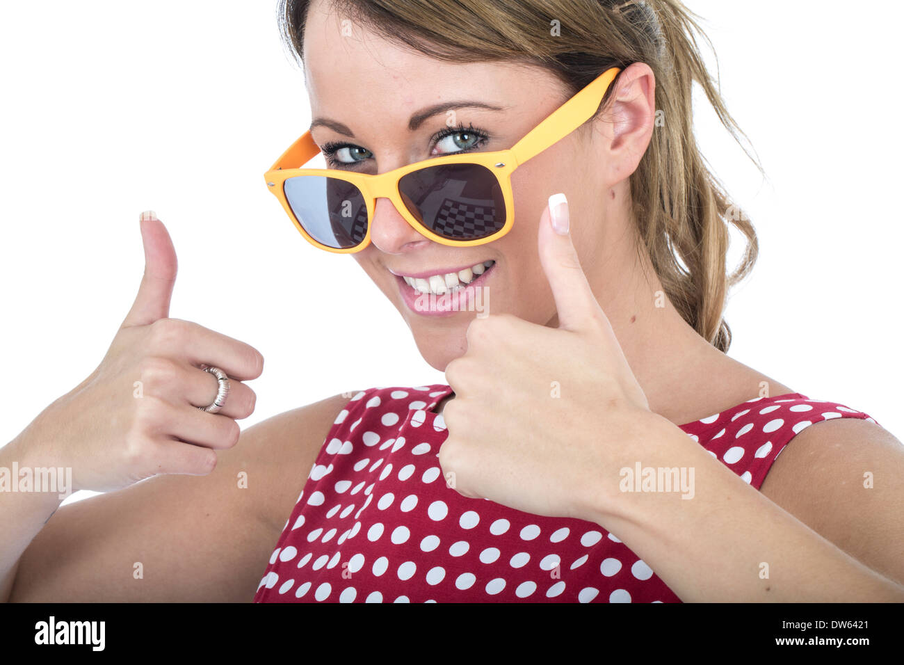 Bella giovane donna caucasica che indossa Red Polka Dot Dress, gesturing con un felice pollice positivo, celebrando il successo, isolato su bianco Foto Stock