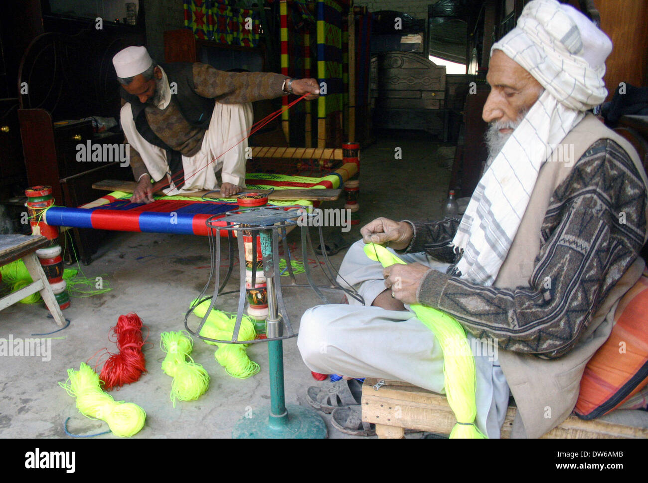 Peshawar. 1 Mar 2014. Un uomo pakistano (L) tesse un semplice letto nel nord-ovest del Pakistan a Peshawar, il 1 marzo 2014. © Ahmad Sidique/Xinhua/Alamy Live News Foto Stock