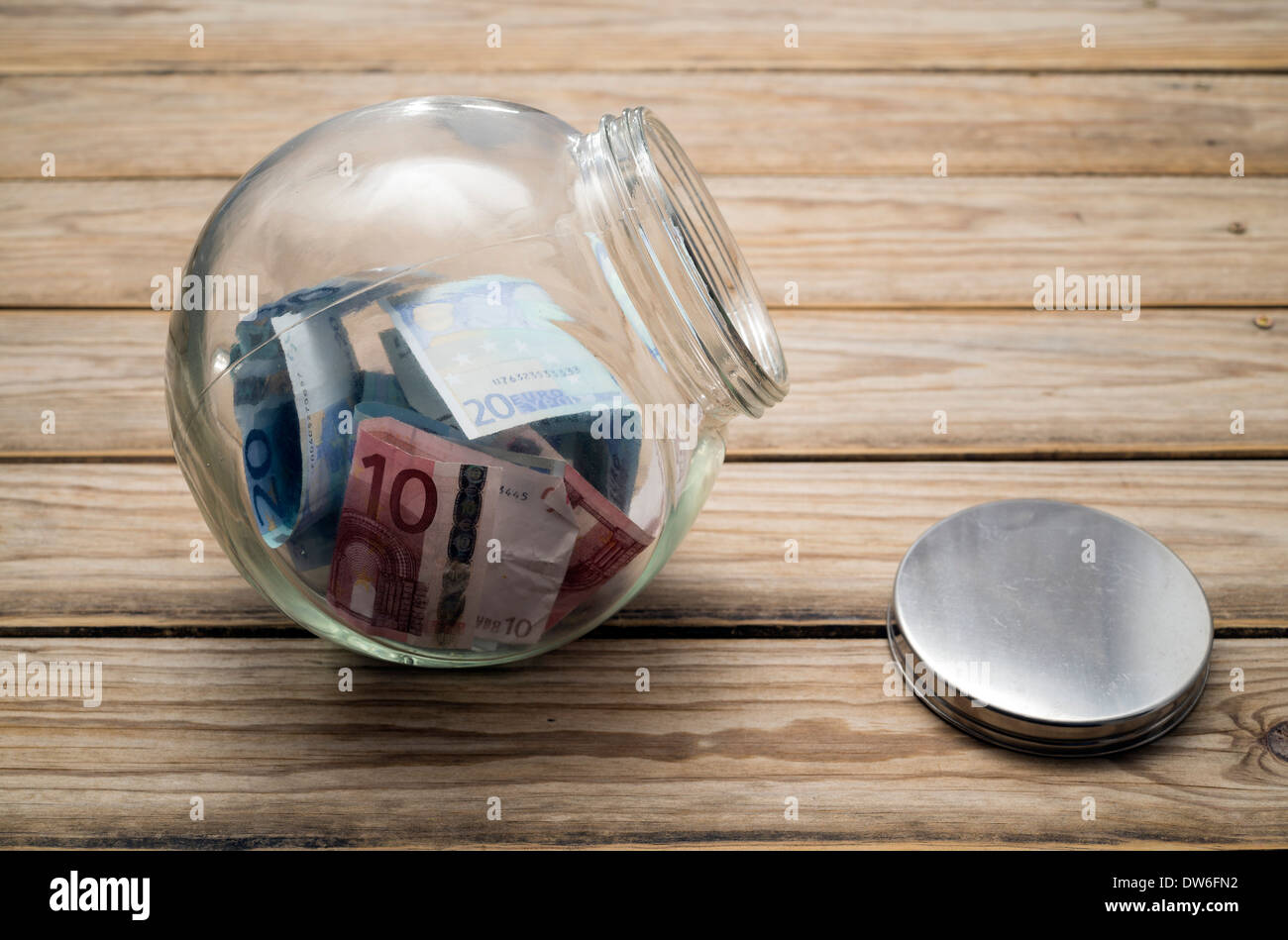 Il denaro in un vasetto di vetro, il concetto di risparmio o di donazione Foto Stock