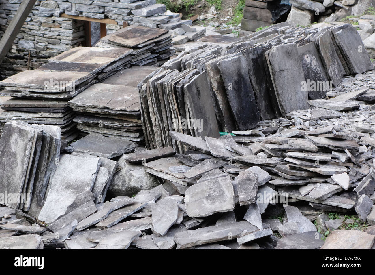 Pile di lastre di roccia su una casa sito in costruzione nel villaggio di Punngpu, Nepal. Foto Stock