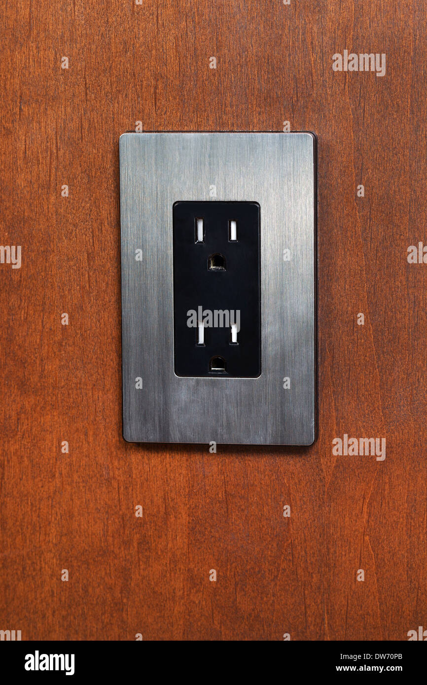 Foto verticale di una presa elettrica e la piastra di facciata in legno di ciliegio parete Foto Stock
