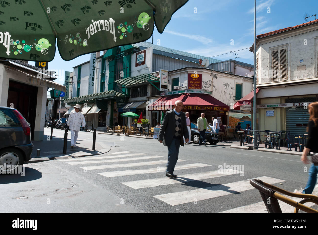 Un uomo cammina lungo una croce a piedi al di fuori della Porte de Clignancourt, uno della Parigi più grandi mercati delle pulci. Foto Stock