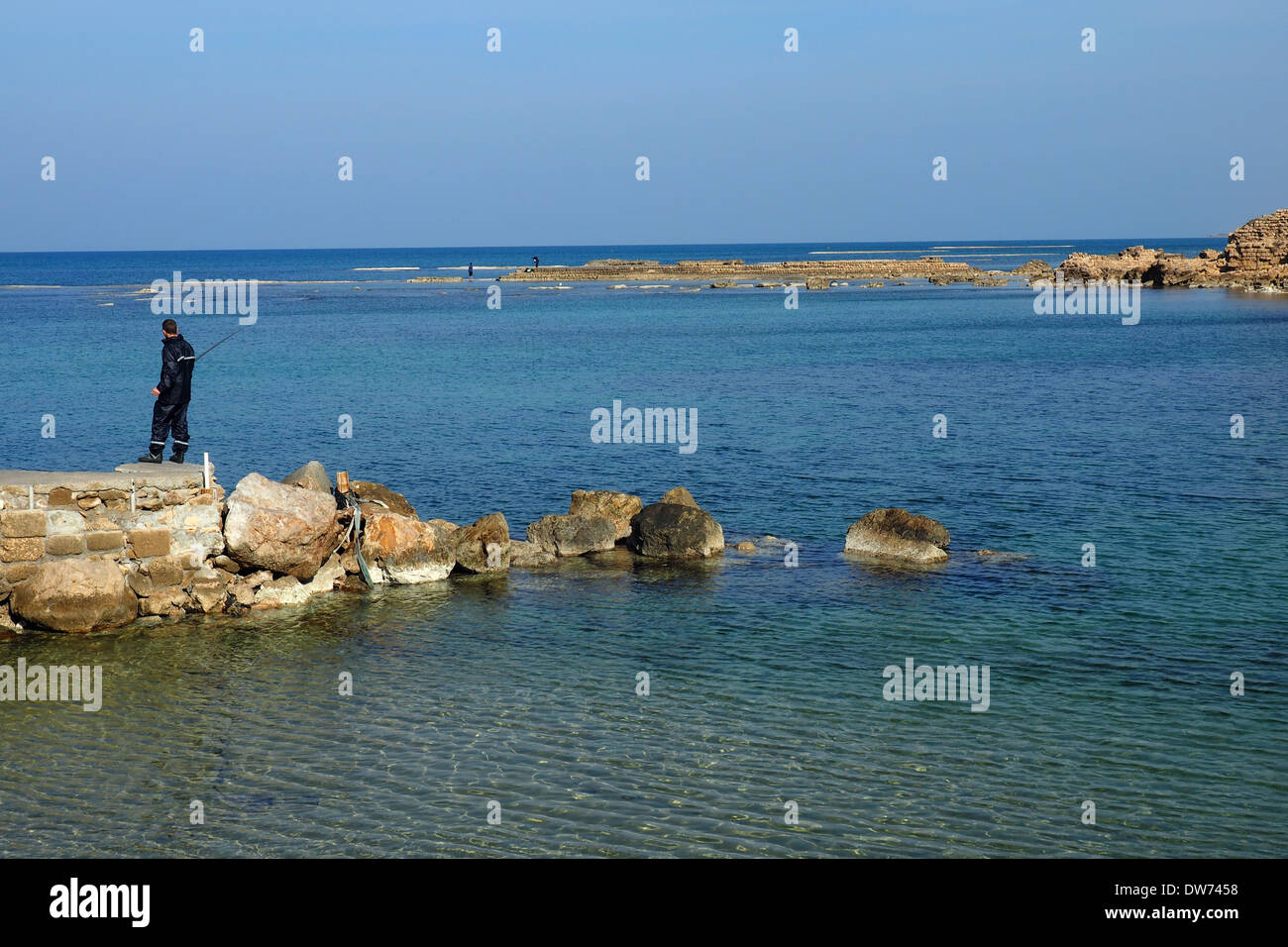 Un uomo pesca in Cesarea Maritima mare mediterraneo Foto Stock