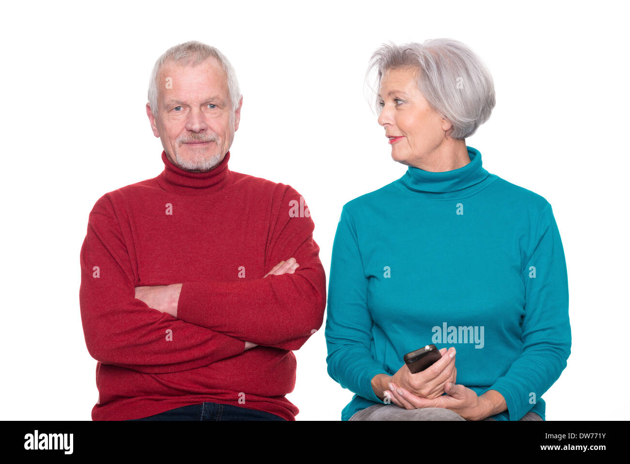 Coppia senior con lo smartphone davanti a uno sfondo bianco Foto Stock