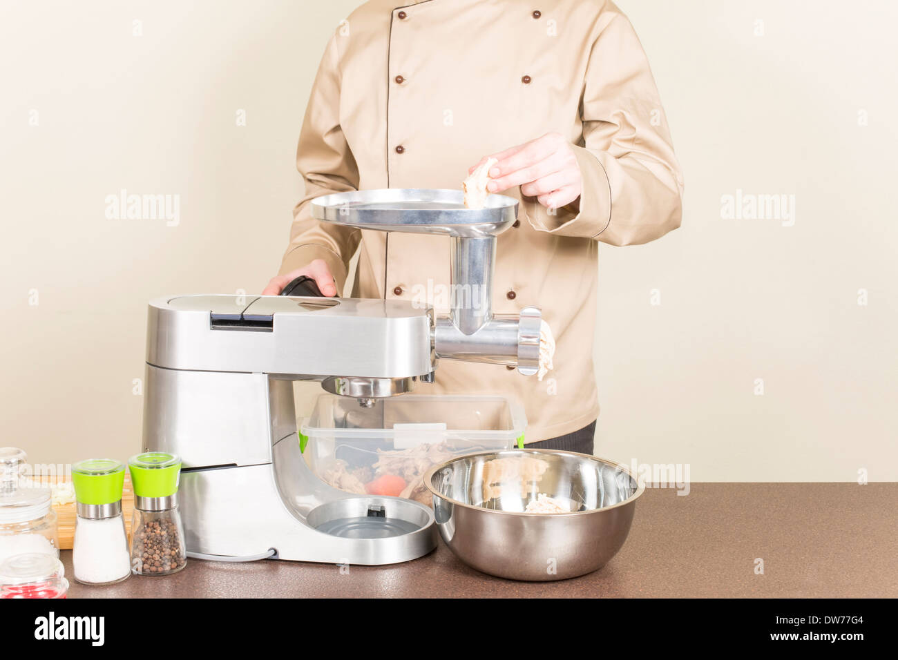 Lo chef rende le carni macinate utilizzando un robot da cucina Foto Stock