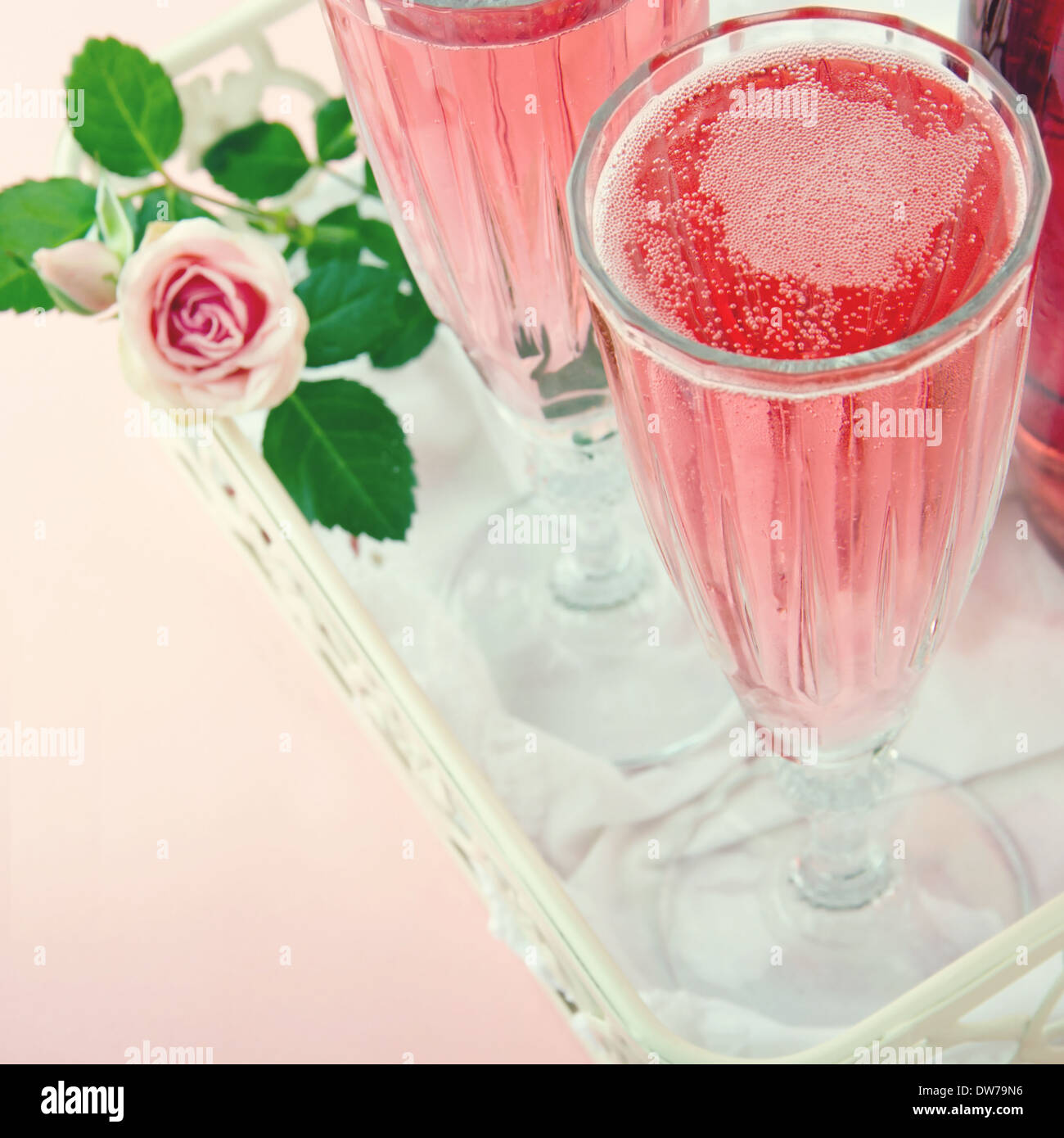Due bicchieri di champagne rosa con una rosa su un pastello vintage colore di sfondo Foto Stock