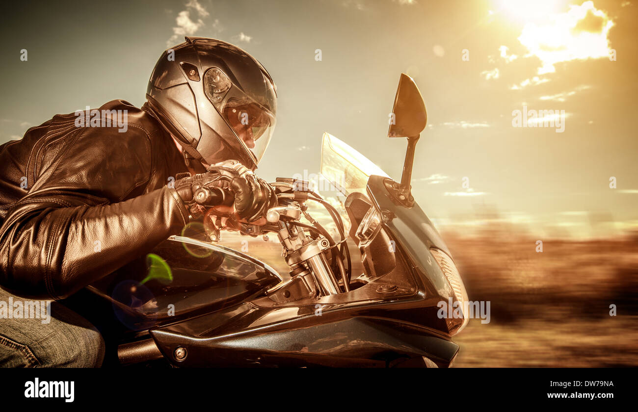 Biker in casco e giacca di pelle racing su strada. Filtro applicato in post-produzione. Foto Stock Biker in casco e giacca di pelle racing su strada. Filtro applicato in post-produzione. Foto Stock