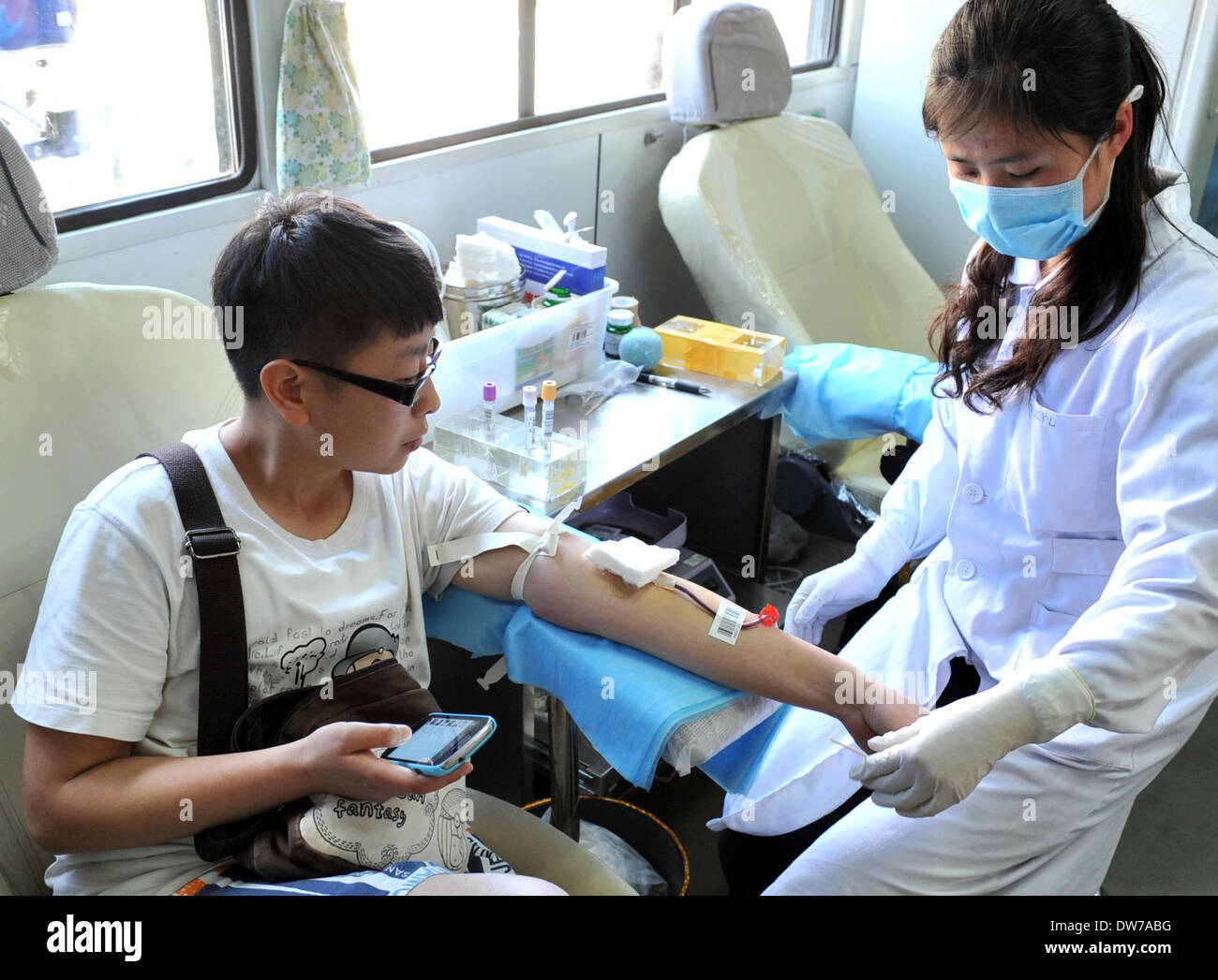 Kunming, la Cina della provincia dello Yunnan. 2 Mar 2014. Un corso di laurea che studia in Kunming dona il sangue in un mobile di raccolta di sangue dalla stazione di Kunming, capitale del sud-ovest della Cina di Provincia di Yunnan, Marzo 2, 2014. Ventinove morti e più di 130 feriti in Kunming Stazione ferroviaria attacco terroristico come delle 8 del mattino di domenica. Come più e più cittadini volontariamente di donare il sangue per i feriti di attacco terroristico, il locale centro di sangue impostare 12 stazioni di raccolta e apertura prolungata ore. © Chen Haining/Xinhua/Alamy Live News Foto Stock