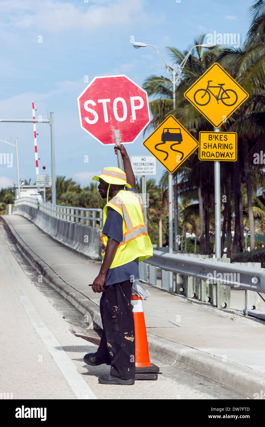 Segnalatore tenendo premuto stop controlli il traffico a Hillsboro ingresso ponte levatoio sulla A1A, Florida, Stati Uniti d'America. Foto Stock