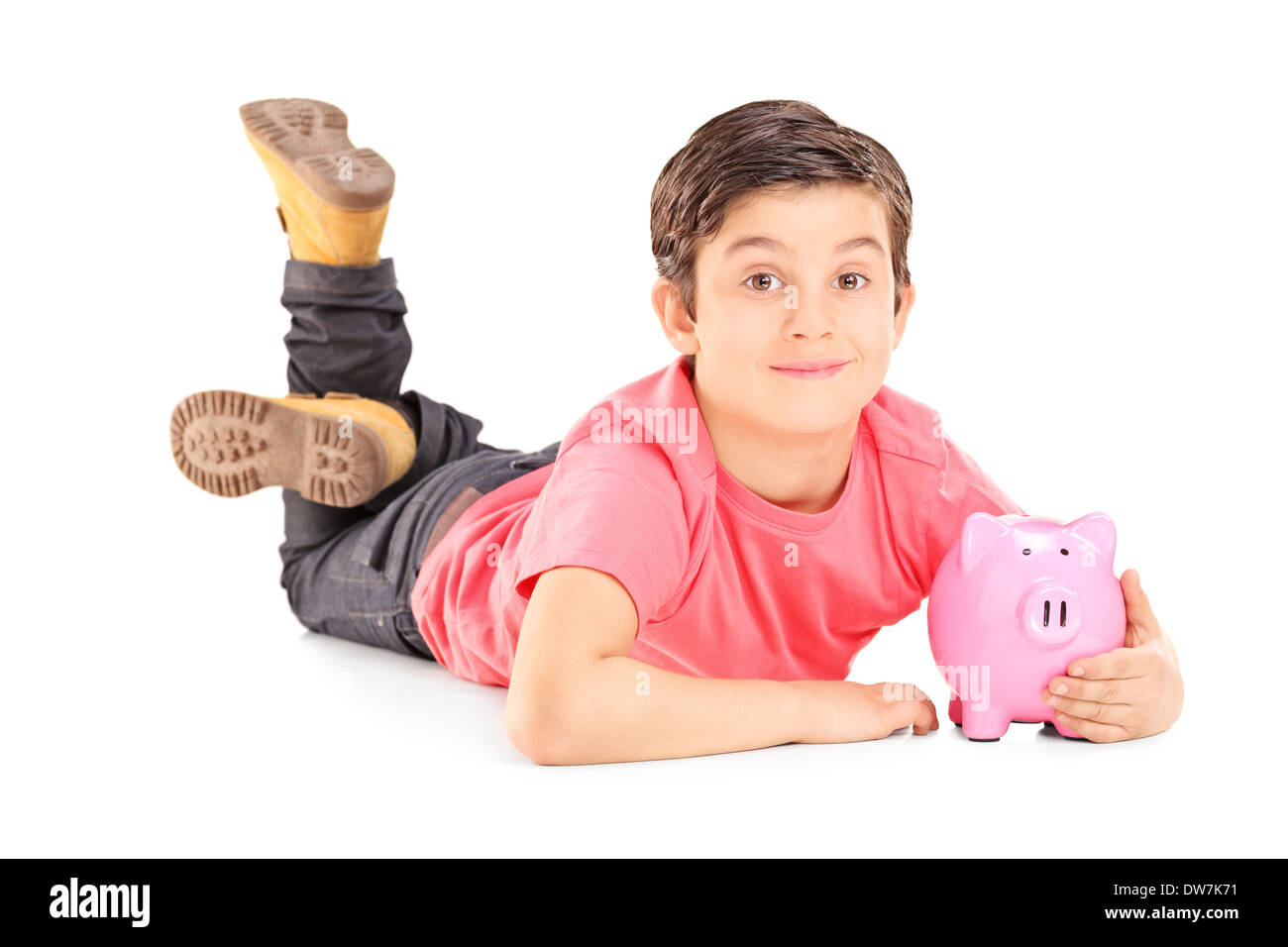 Allegro ragazzo posa sul pavimento e tenendo un piggybank Foto Stock