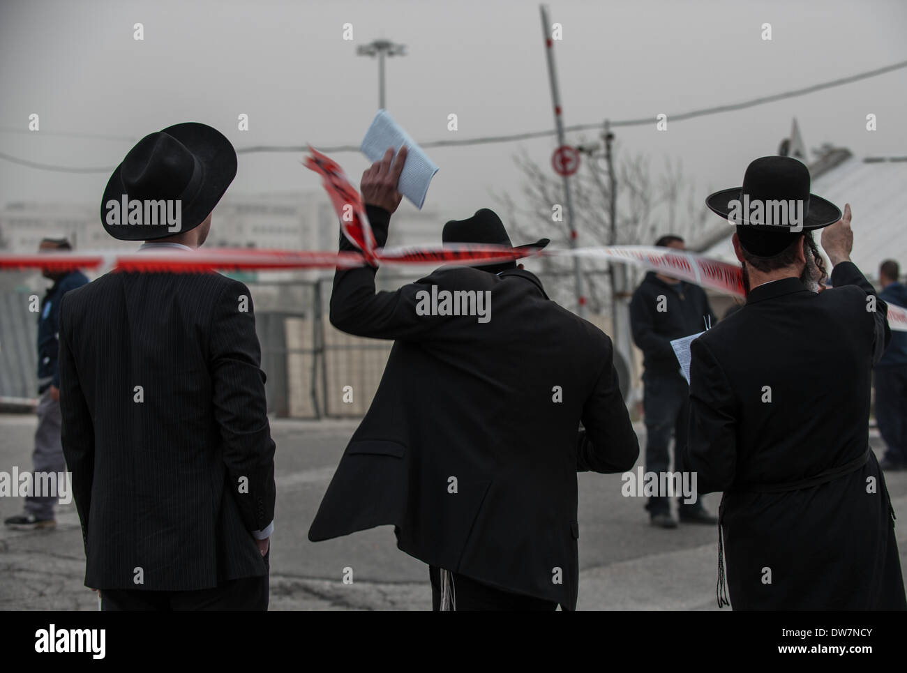 Gerusalemme. 2 Mar 2014. Un ultra-ebreo ortodosso attraversa un cordone di sicurezza durante una massa anti-progetto di rally in Gerusalemme, 2 marzo 2014. Centinaia di migliaia di ultra- ebrei ortodossi raccolse Domenica a Gerusalemme per protestare contro un piano del governo per arruolare i loro giovani nell'esercito. Il governo sta spingendo per un progetto di legge di reclutamento ultra-ortodossi e mettere le sanzioni penali, compresa la detenzione, su progetto di dodgers. Credito: Li Rui/Xinhua/Alamy Live News Foto Stock