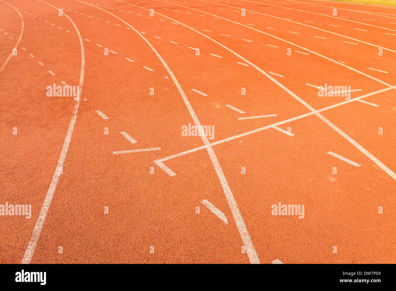 Rosso il colore e la consistenza della pista atletica corsie con la linea bianca Foto Stock