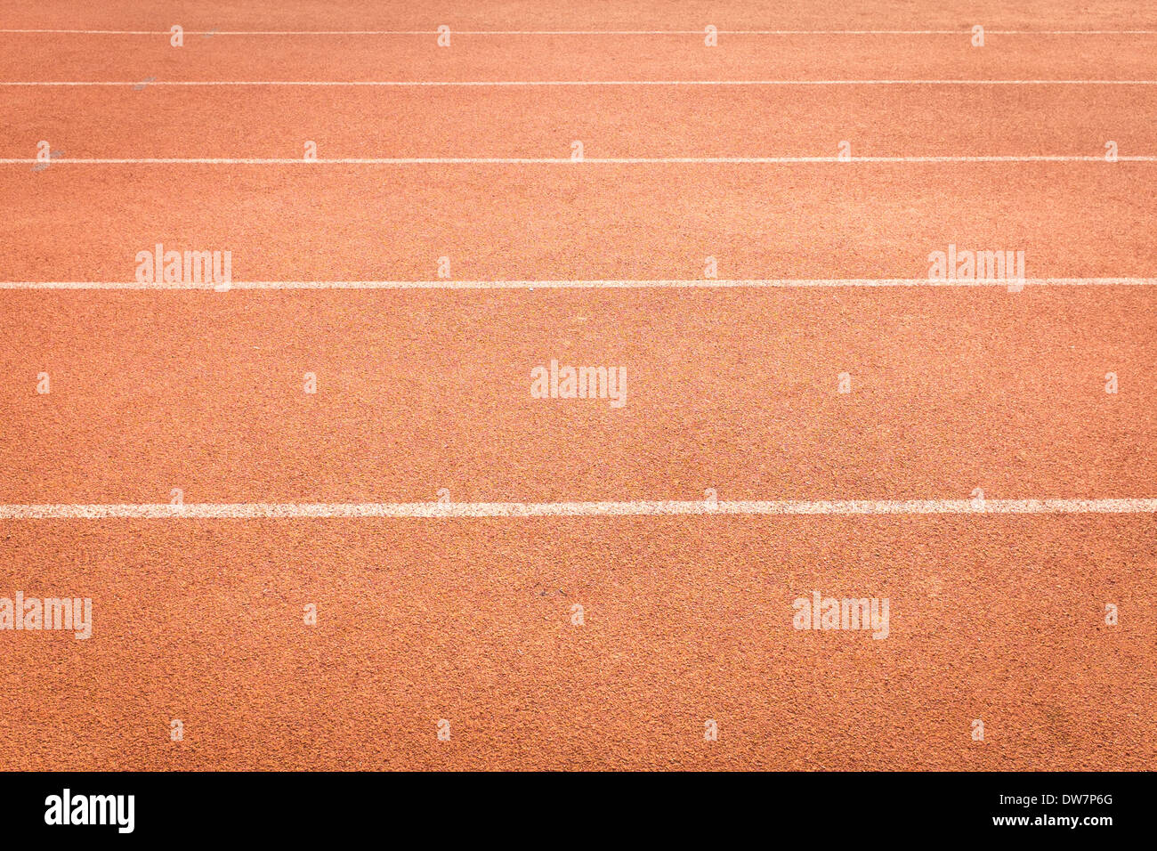 Rosso il colore e la consistenza della pista atletica corsie con la linea bianca Foto Stock