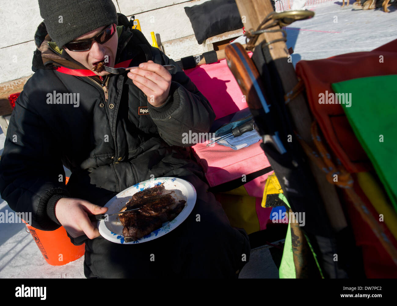 Willow, Alaska, Stati Uniti d'America. 2 Mar 2014. Marc Lester / Anchorage Daily News .Musher Wade Marrs mangia una grande ribeye prima racing inizia. Racing ha iniziato per il 2014 Sentiero Iditarod Sled Dog Race sul Lago di salice domenica pomeriggio, 2 marzo 2014. Sessanta nove squadre iniziato questo anno di Iditarod. Credito: Marc Lester/Anchorage Daily News/ZUMAPRESS.com/Alamy Live News Foto Stock