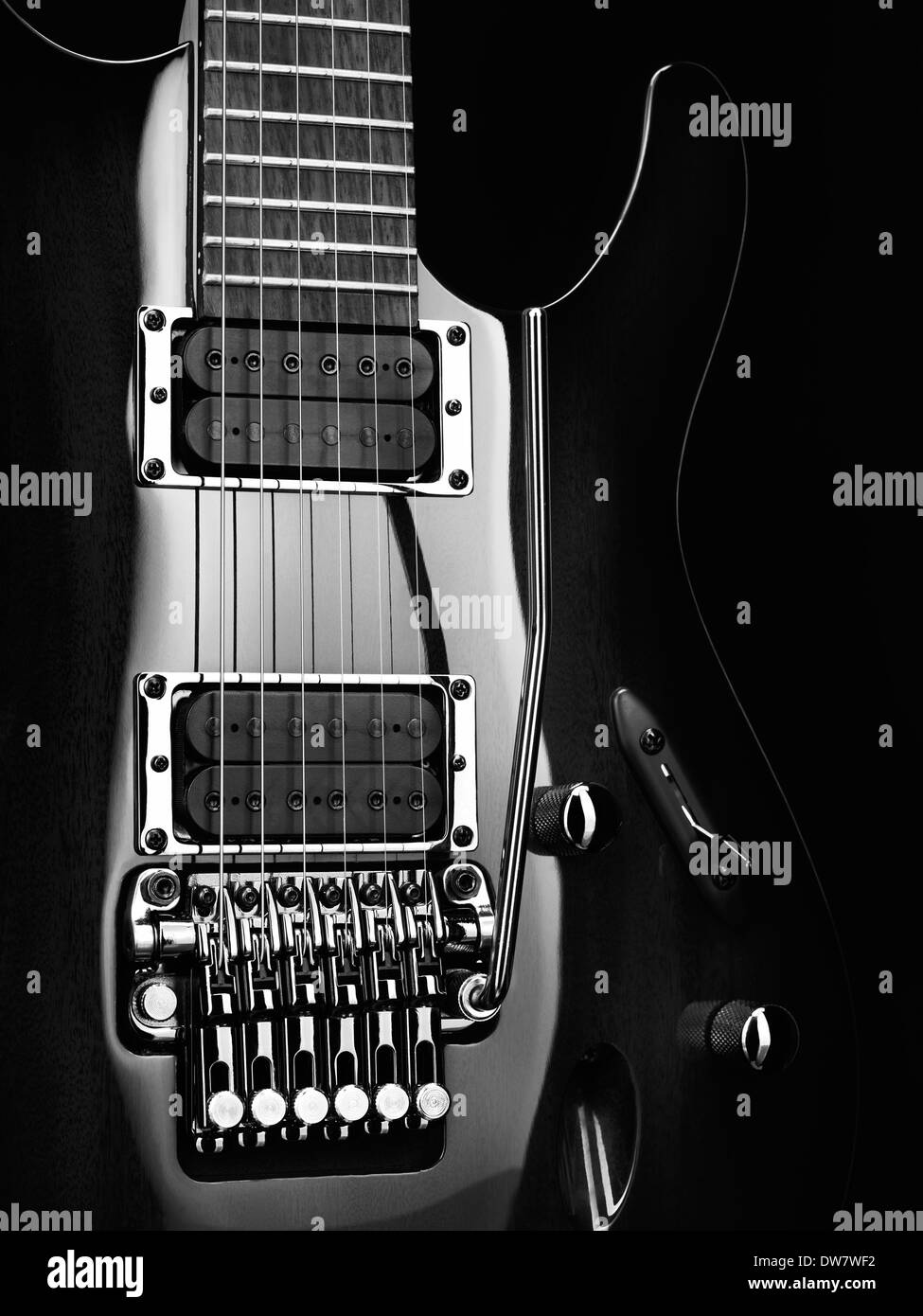 Primo piano artistico di una chitarra elettrica Ibanez con le parti cromate su sfondo nero foto in bianco e nero Foto Stock