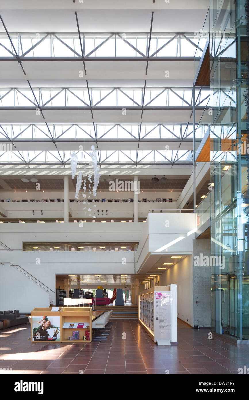 Genk biblioteca pubblica, a Genk, in Belgio. Architetto: Claude Vasconi, 2008. Atrium visto dall ingresso principale con ascensore di vetro albero sul rig Foto Stock