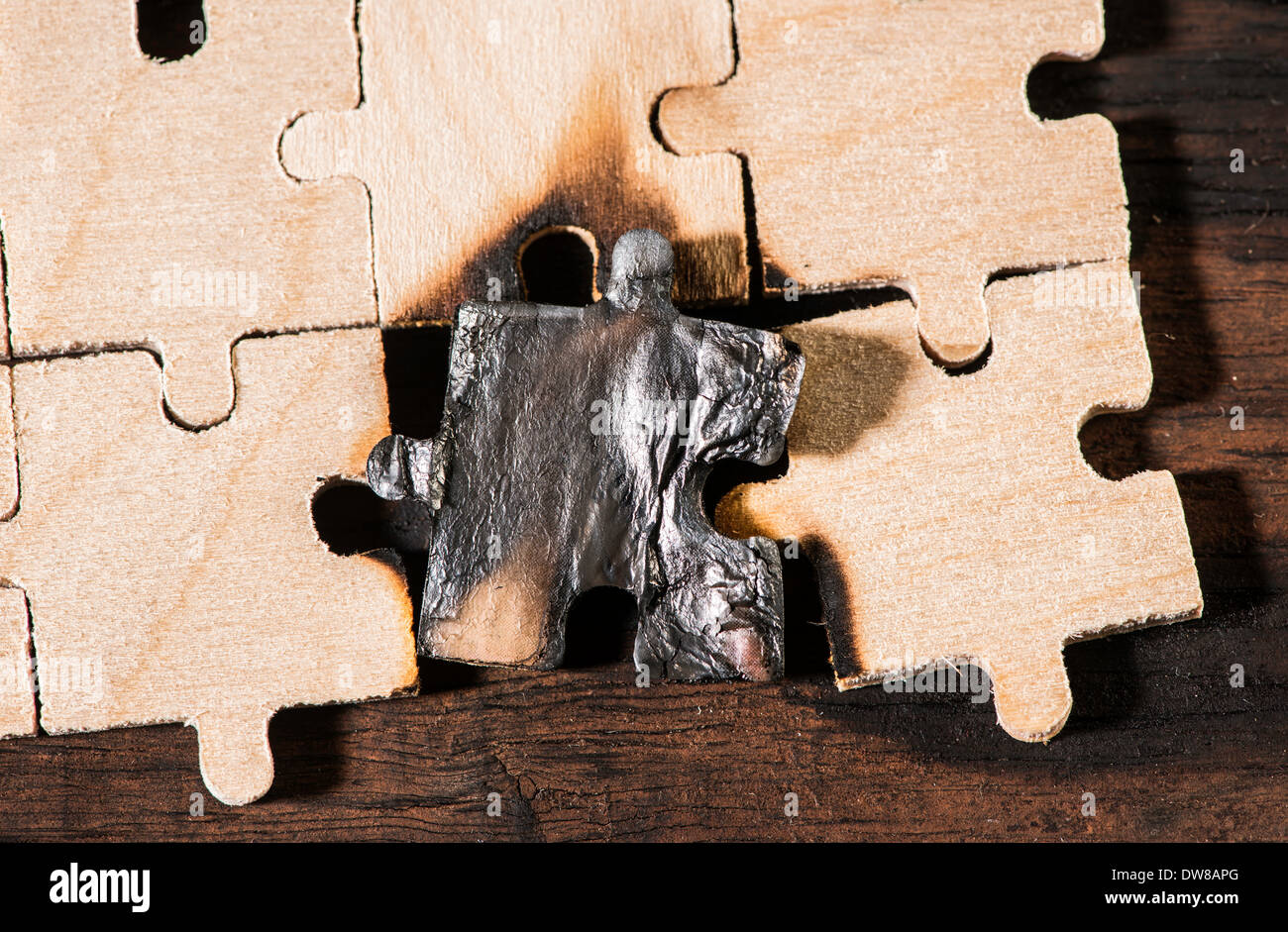 Masterizzazione di puzzle in legno su sfondo scuro. Close up Foto Stock
