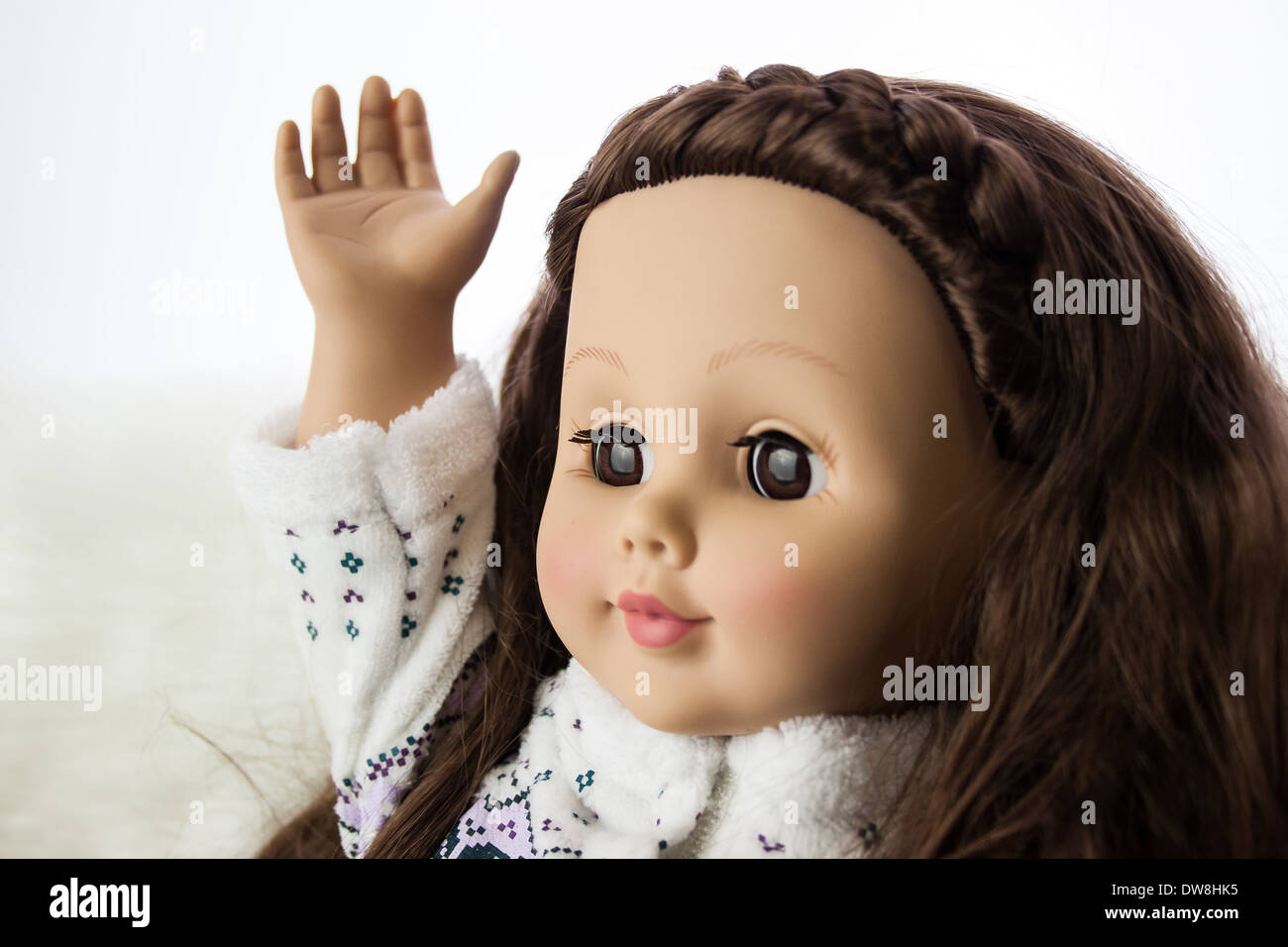 Una bambola giocattolo con la mano alzata come se fare una domanda in un'aula. Foto Stock