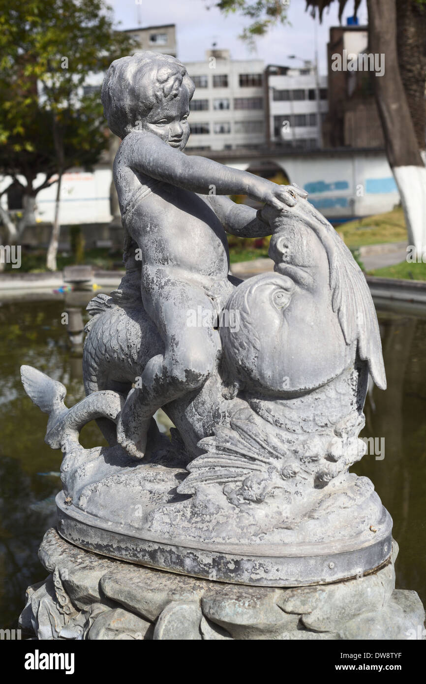 Statua di un ragazzo seduto su un pesce nella fontana nel Parque Sucre, Riobamba, Ecuador Foto Stock