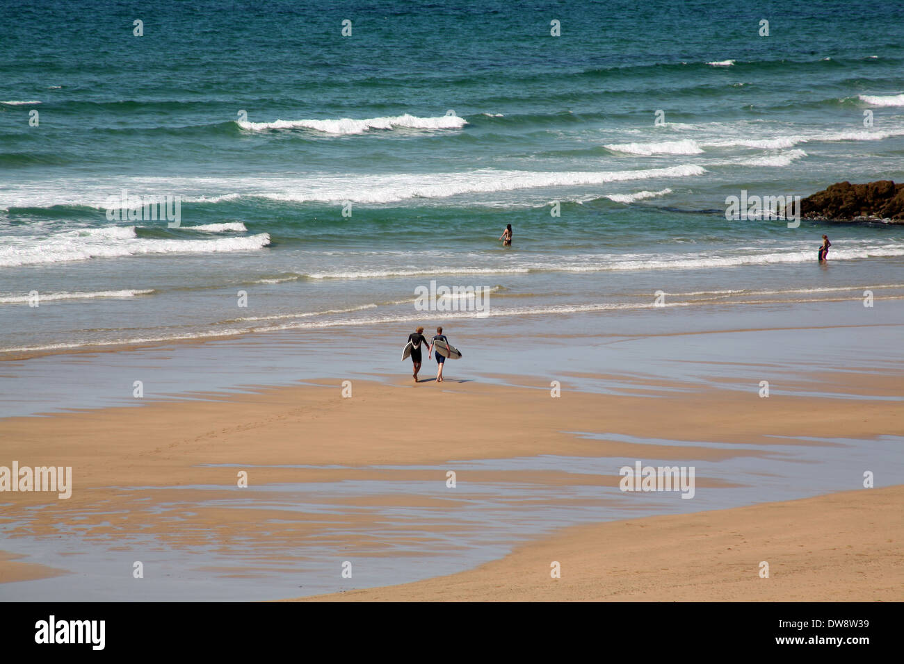 Surfers di camminare sulla spiaggia Foto Stock