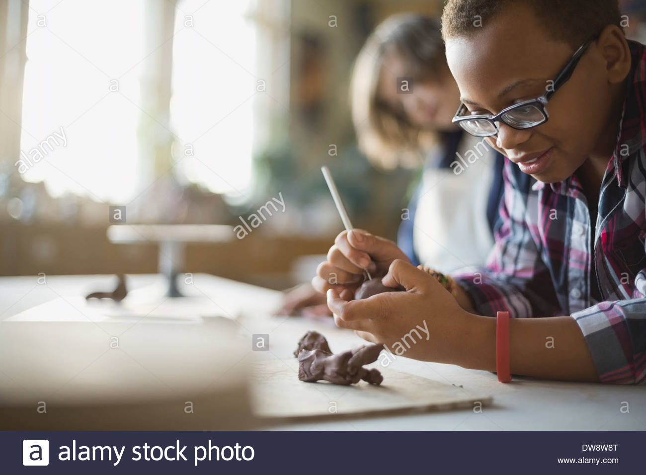 Ragazzo creazione di statuine di argilla in classe d'arte Foto Stock