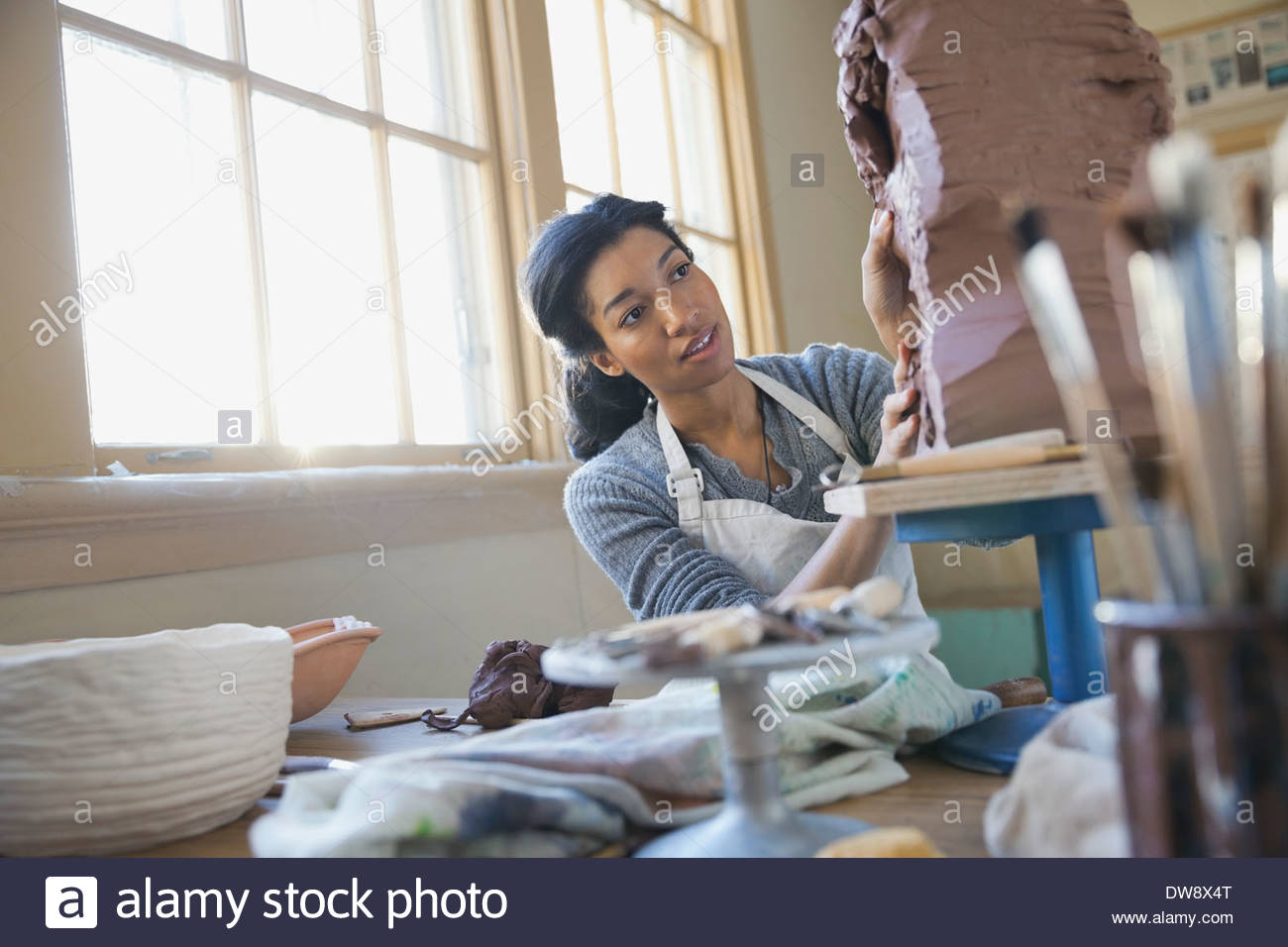 Studenti che lavorano sulla scultura in argilla in classe d'arte Foto Stock