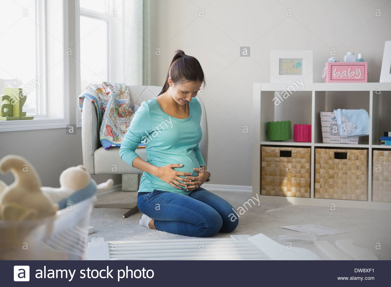 Donna incinta assemblaggio culla a casa Foto Stock