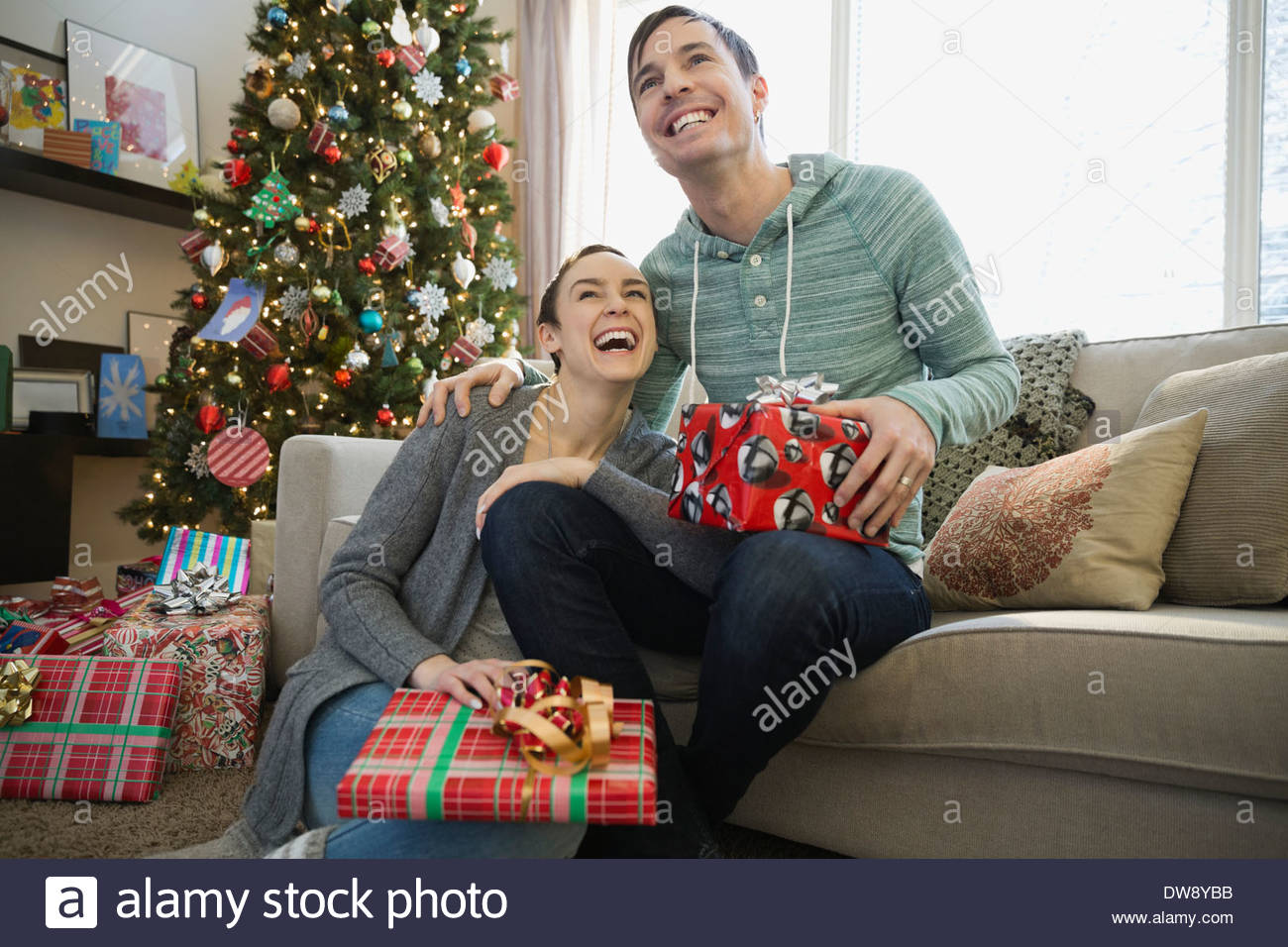 Allegro giovane con doni di Natale a casa Foto Stock
