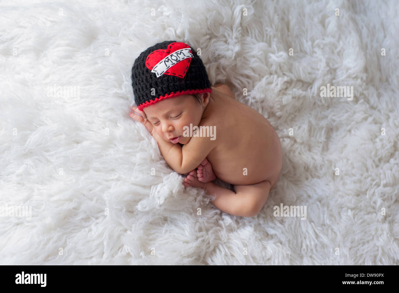 Sleeping baby boy indossando un 'amore' Mom beanie. Foto Stock