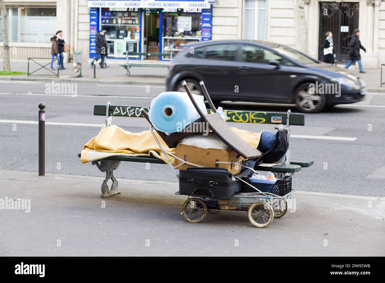 Una persona che dormiva grezzo su un banco di strada in Parigi Francia Foto Stock