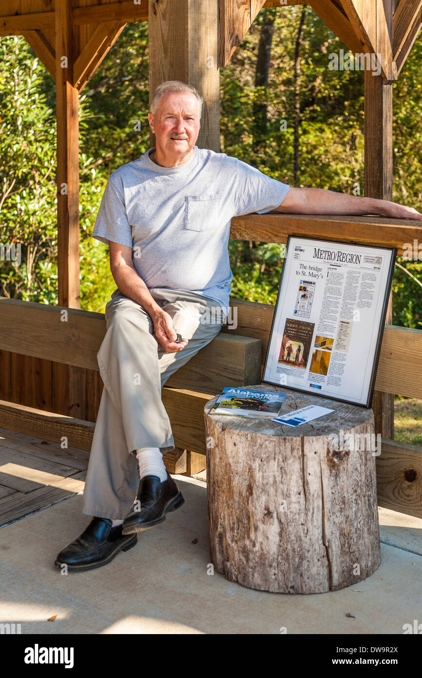 Prezzo di Claude si siede accanto a incorniciato news storia circa la sua proprietà privata ponte coperto al di fuori di Elberta, Alabama Foto Stock