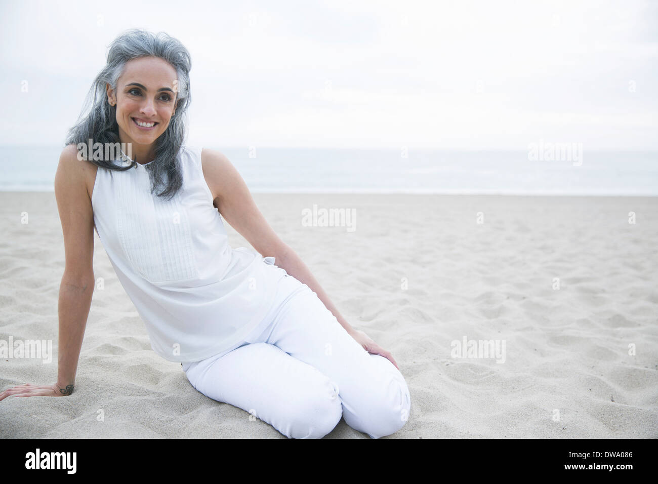 Donna matura rilassante sulla spiaggia di Los Angeles, California, Stati Uniti d'America Foto Stock