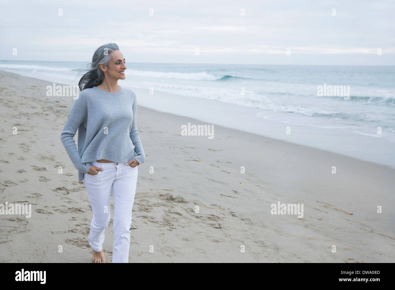 Donna matura camminando sulla spiaggia di Los Angeles, California, Stati Uniti d'America Foto Stock