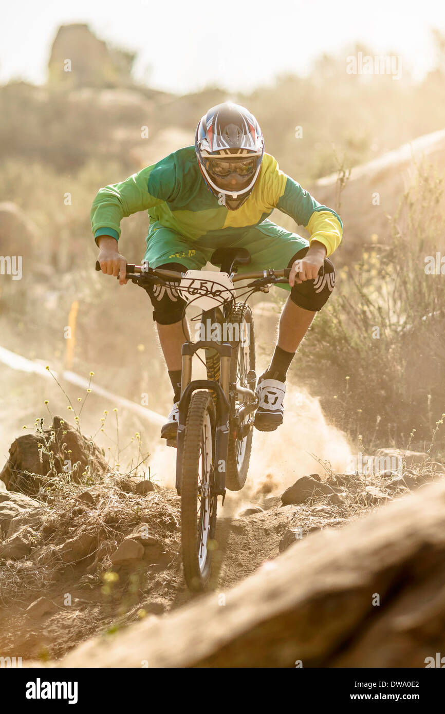 Maschio di mountain biker racing su pista polverosa, Fontana, in California, Stati Uniti d'America Foto Stock