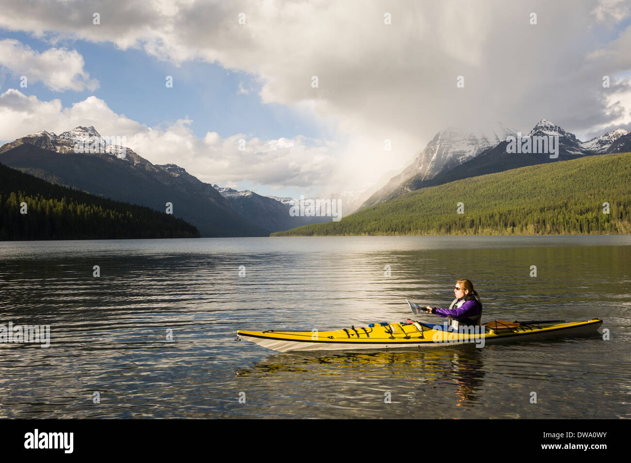 Kayak femminile su Santa Maria Lake, il Parco Nazionale di Glacier, Montana, USA Foto Stock