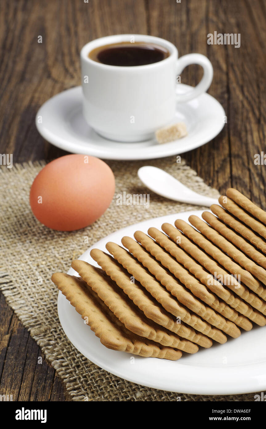 La prima colazione con i cookie, l'uovo e la tazza di caffè Foto Stock